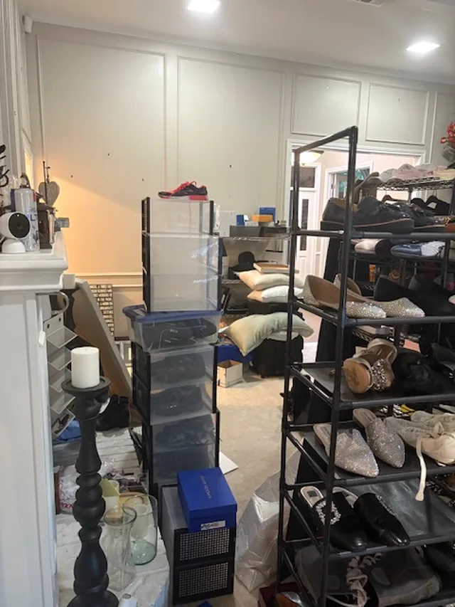 Shoe racks and clear storage bins along the living room wall