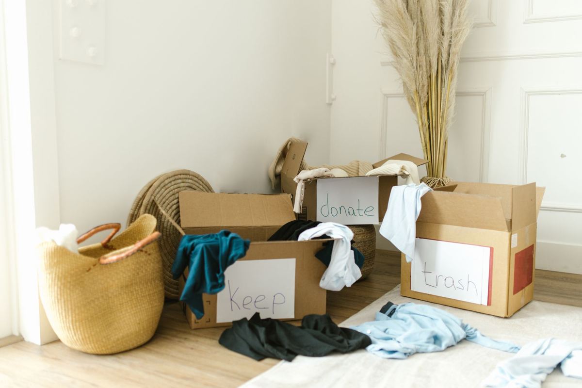 Boxes of clothes and household goods sorted into donate and keep piles