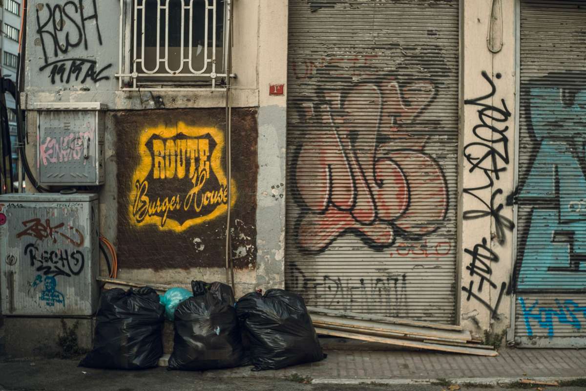 Full trash bags piled outside a building's door