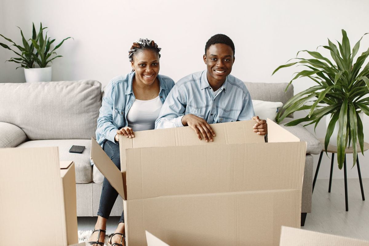 A couple unpacking a moving box in their living room