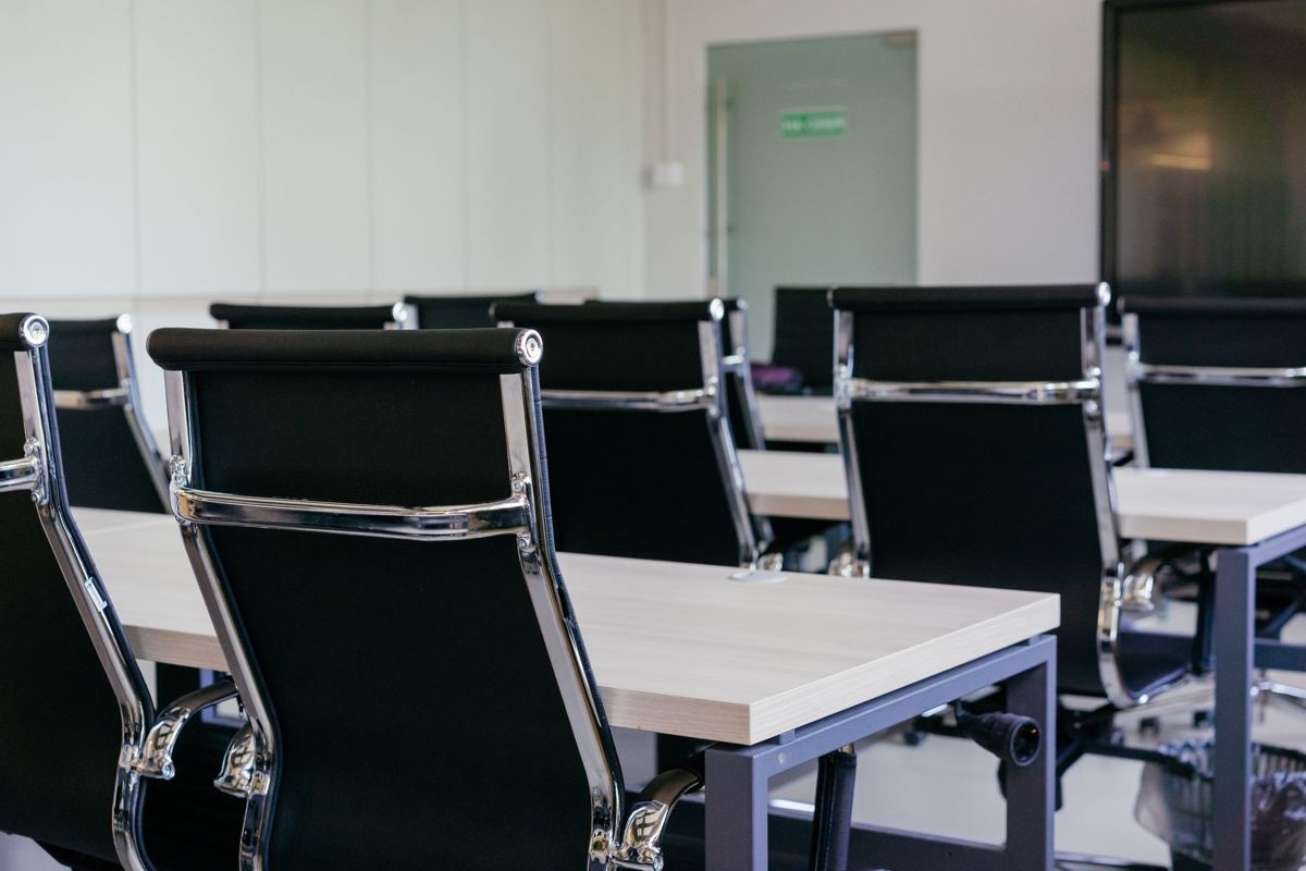 Rows of empty office desks and chairs