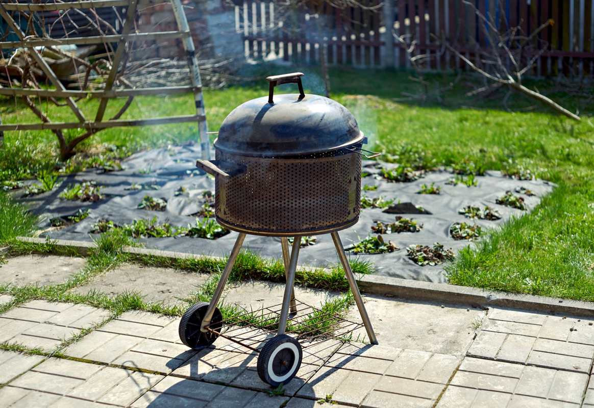 An old kettle grill on a backyard patio