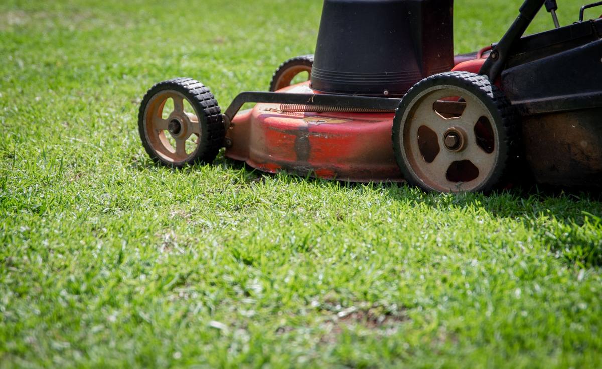 An old red push mower on a lawn
