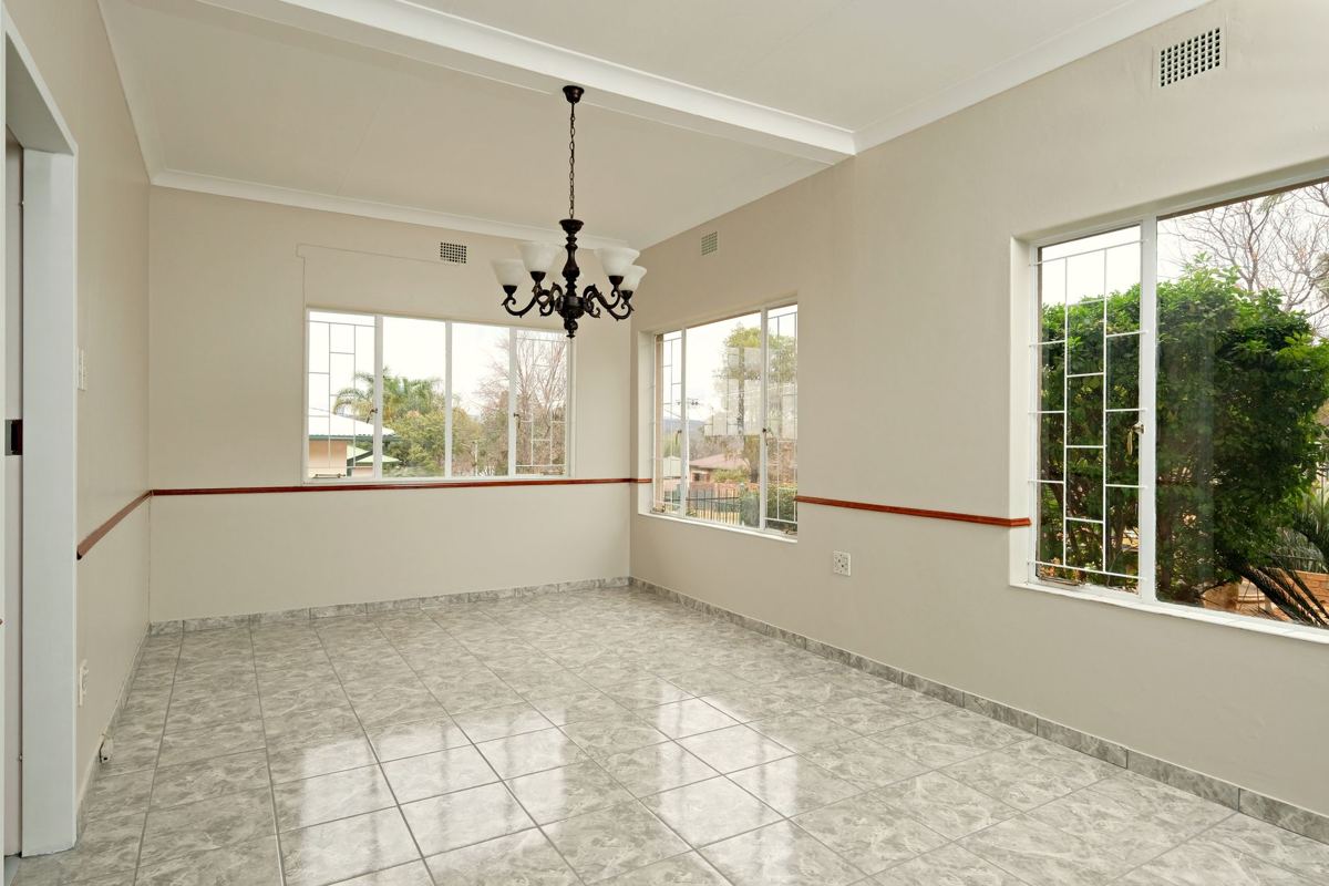 An emptied room with tile floors and a chandelier