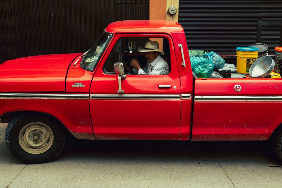 A red pickup truck with items loaded in the bed