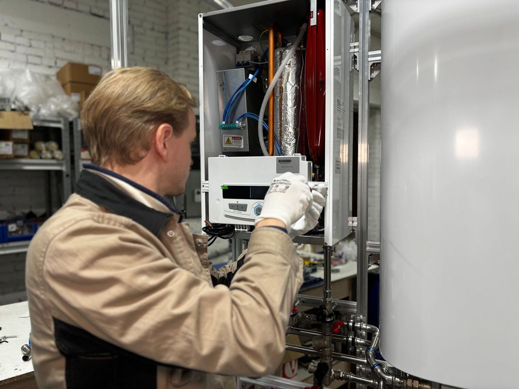 A technician servicing a tank water heater