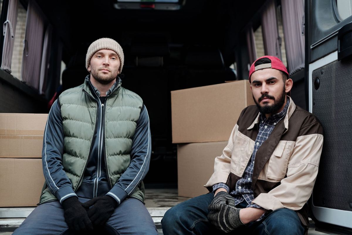 Two workers sitting in the back of a work van