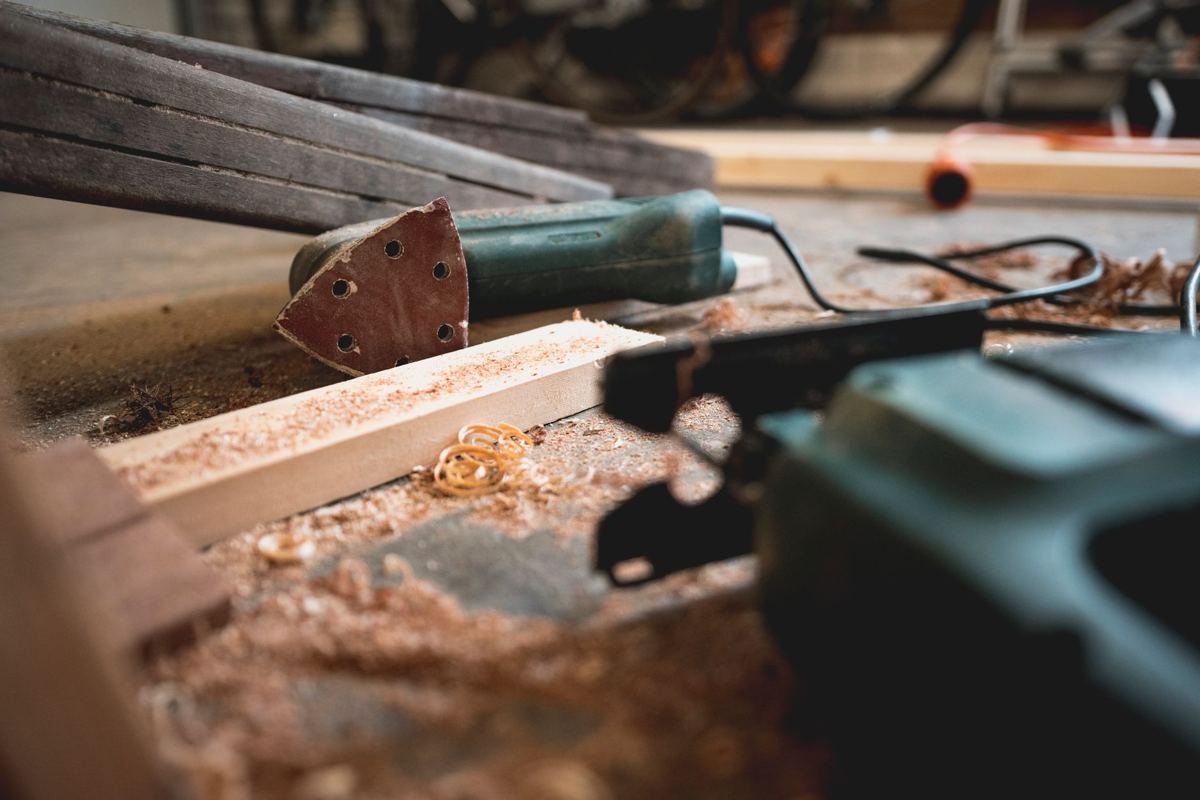 Power tools and sawdust on a woodworking bench