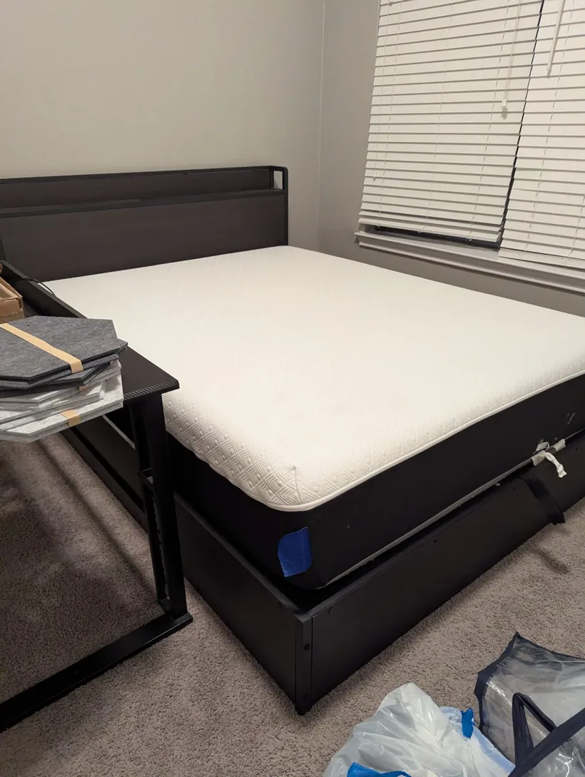 A bed frame and mattress in a bedroom, ready for pickup